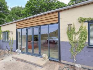 a house with glass doors on the side of it at Sumner Lodge in Kyre Magna