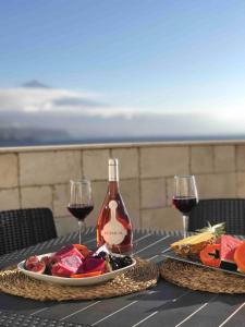a table with a plate of food and a bottle of wine at WONDERFUL Sea Views El Pris in El Pris