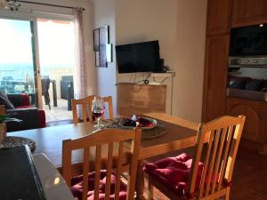 a dining room with a table and chairs and a television at WONDERFUL Sea Views El Pris in El Pris