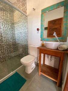 Un baño con inodoro, lavabo y ducha. en Pousada Recanto Mandalah, en Cunha