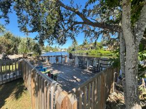 a wooden deck next to a river with a tree at Manatee Spacious Updated On River 1 Mi to Beach Kit W&D in Bonita Springs