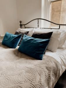 a bed with three blue pillows on it at Rialto luxury apartments Bath ! in Bath +54 photos
