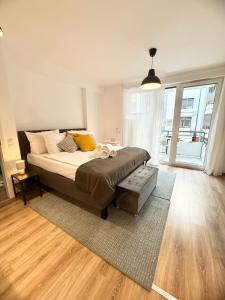 a bedroom with a bed and a large window at Rita Apartman privát parkolóval és erkéllyel in Kecskemét
