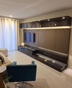 a living room with a couch and a television at NOVO e DECORADO no Centro de Canela! in Canela