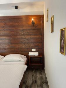 a bedroom with two beds and a wooden wall at Hotel Hani in Peje