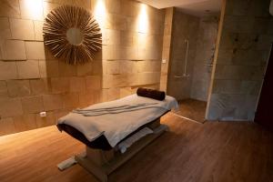 a bathroom with a shower and a bed and a mirror at Les Jardins de Beauval in Saint-Aignan