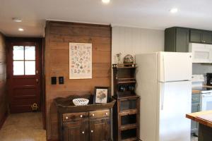 ShirleyにあるBeautiful Cabin in Natureの白い冷蔵庫付きのキッチン、木製の壁