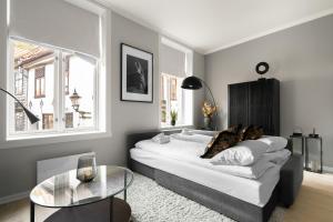 ein Schlafzimmer mit einem großen Bett und einem Glastisch in der Unterkunft Bergen Beds Apartments - A Front Row Experience in Bergen