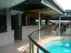 a building with a swimming pool in front of it at Cynergy Suites Festac Town - Standard in Amuwo