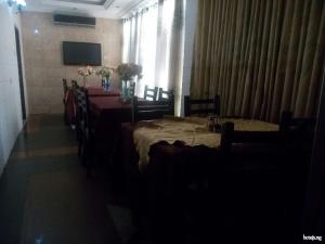 a dining room with tables and chairs and a television at Cynergy Suites Festac Town - Standard in Amuwo