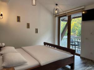 a bedroom with a bed with a view of a balcony at Hotel Hani in Peje