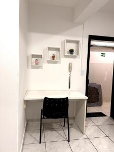 un escritorio blanco en una habitación con una silla negra en Smart Loft Premium Moderno e Inteligente no Centro Unidade 04, en Presidente Prudente