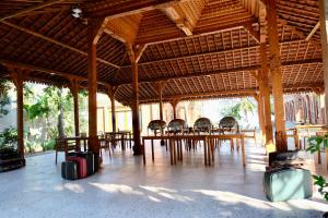 a large wooden pavilion with tables and chairs and luggage at Pulojava Resort in Karimunjawa