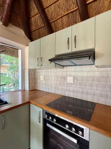 Una cocina con gabinetes blancos y un horno de estufa. en Tranquility, en Ciudad del Cabo