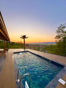 a swimming pool with a sunset in the background at Asil Villas in Sapanca