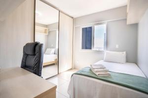 a small bedroom with a bed and a mirror at Point Convenience by Marzani Host in Goiânia +14 photos