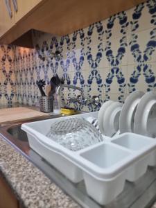 un bancone della cucina con uno scolapiatti bianco nel lavandino di Happy House - Central Apartment a Faro