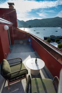 a balcony with a table and chairs and a view of the water at MÍMESIS 11 - Boutique Hotel in Como