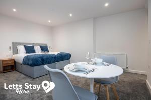 a bedroom with a bed and a table and chairs at Morecambe Bay Stays in Morecambe