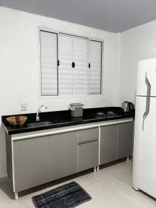 a kitchen with a sink and a refrigerator at Brisa do Forte in São Francisco do Sul