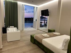 a bedroom with a bed and a tub and a sink at Lumeris lakeview Suites and SPA in Rubjekë