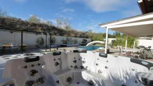 a white patio with a pool and a table at Casa Jardin del Valle TuCasaTemporal in Seseña