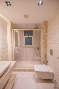 a bathroom with a shower and a toilet and a sink at Hacienda Bay Villa with private pool in El Alamein