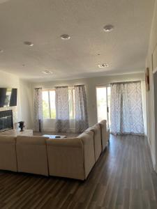 sala de estar amplia con sofá y ventanas en #Marbella Lane - Majestic Desert Mountain Views, en Desert Hot Springs