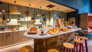 a bakery with a counter with bread and pastries at greet Hotel Reims Tinqueux in Reims