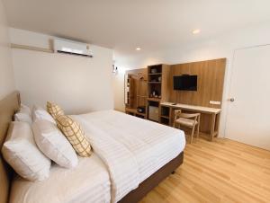 Un dormitorio con una cama y un escritorio con televisión. en Baan Imm Sook Resort, en Chao Lao Beach