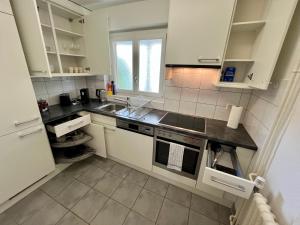 a kitchen with white cabinets and a sink at Langgrütstrasse 21, 8047 Zürich, Switzerland in Zürich