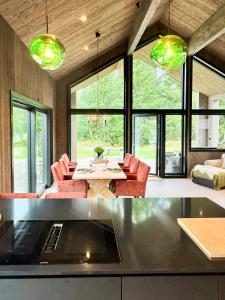 Una cocina y una sala de estar con mesa y sillas. en Modern Cabin By The Lake In Kvelia, 