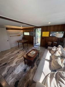 ShirleyにあるCabin in Nature at Cliffwood Colonyのソファとテーブルのあるリビングルーム