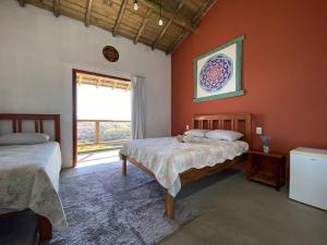 Un dormitorio con dos camas y una gran ventana. en Pousada Recanto Mandalah, en Cunha 63 fotos más