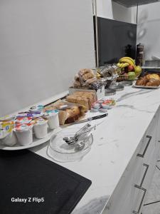 Una línea de buffet con diferentes tipos de pan y pasteles. en CASA MIA GUESTHOUSE AFFITTA CAMERE Foresteria, 
