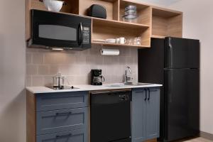 cocina con nevera negra y microondas en Candlewood Suites Houston Space Center - Webster, en Webster