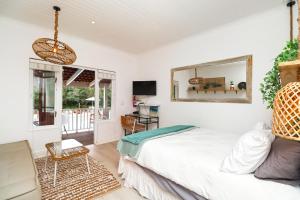 a bedroom with a bed and a desk and a mirror at Dune Sanctury in Keurboomstrand