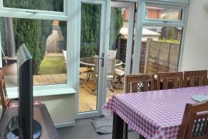 ein Raum mit einem Tisch und einer Terrasse mit Schiebetüren in der Unterkunft Cottage - Sleeps 4 - Garden - Parking in Chorley + 3 Fotos