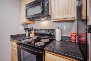 une cuisine avec une cuisinière et un micro-ondes dans l'établissement CozySuites at the Banks gym pool 13, à Cincinnati 19 autres photos