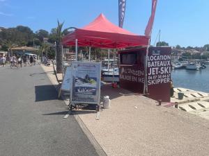 a red tent on a sidewalk next to a marina at Le Rafifou Porquerolles in Hyères