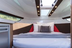 a bed in the middle of a room with windows at Le Rafifou Porquerolles in Hyères