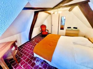 a bedroom with a white bed and a red chair at Le clos des écureuils in Amboise