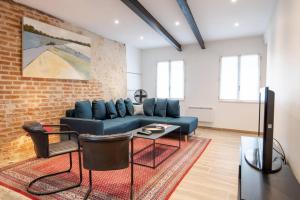 a living room with a blue couch and a brick wall at La Maison Renaissance Amboise 4 bedroom house in Amboise