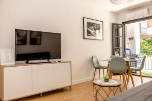 a living room with a flat screen tv on a white cabinet at Apartamento en centro de Cazorla con vista a la montaña in Cazorla