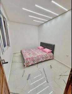 a room with a bed with pink pillows on it at Elhanaa 