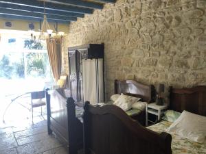 a bedroom with a stone wall with a bed and a stone wall at Le mas du murier - Portes de Provence - Mas de 1890 rénové avec climatisation in Loriol-sur-Drôme +54 photos