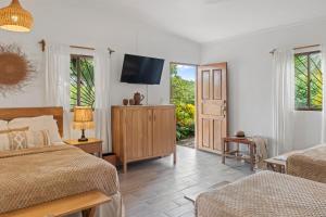 a bedroom with two beds and a flat screen tv at Nicawaves in Popoyo