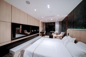 a bedroom with a large white bed and a fireplace at X-Digital HOTEL in Bắc Ninh