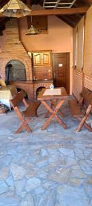 - une table et des chaises dans une pièce dotée d'un sol en pierre dans l'établissement Marija apartmani, à Kraljevo