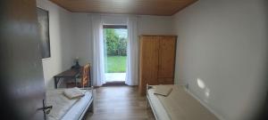 a room with two beds and a large window at Reihenendhaus bei Nürnberg in Petersaurach